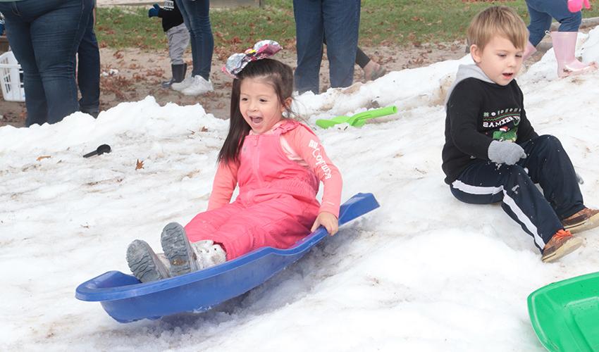 Girl sliding down the snow hill