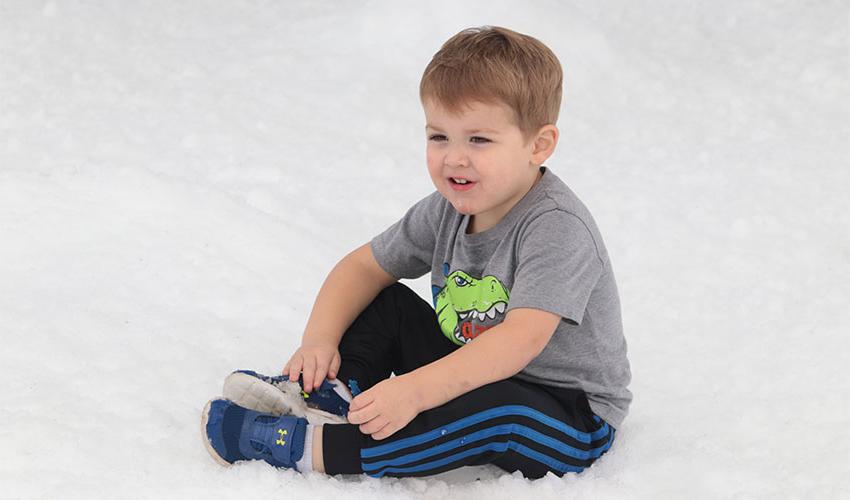 Little boy sitting on the snow